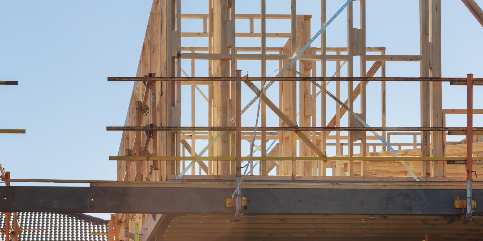 Ossature bois d'un bâtiment en construction, avec échafaudage